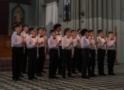 A group of boys holding candles and singing