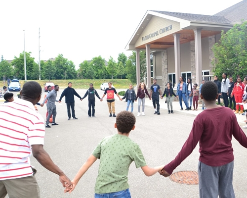 A group of kids holding hands together in a circle
