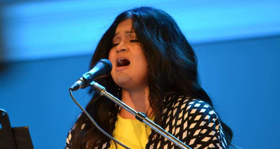 Singer sitting at the piano and a mic