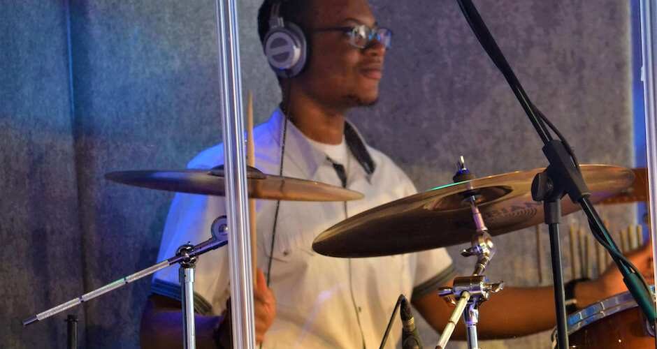 Man drumming inside a drum cage